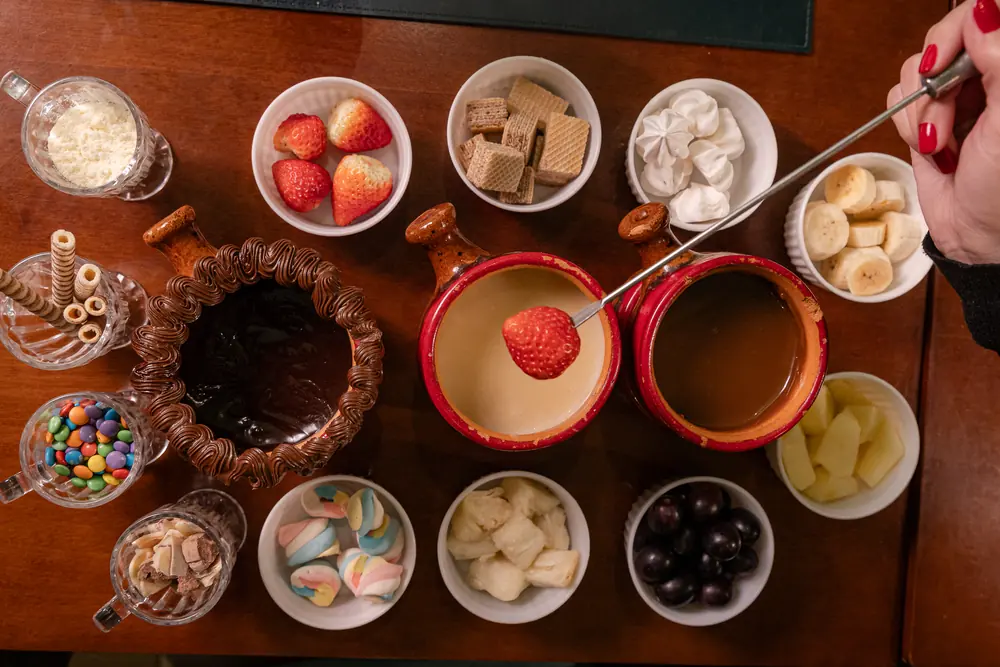 Fondue de chocolate com frutas, wafer, marshmallow e confeitos