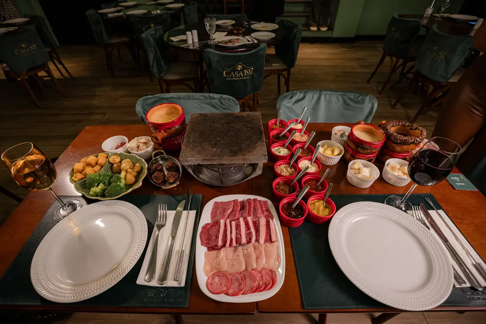Mesa de fondue completa montada no salão da Casa 197