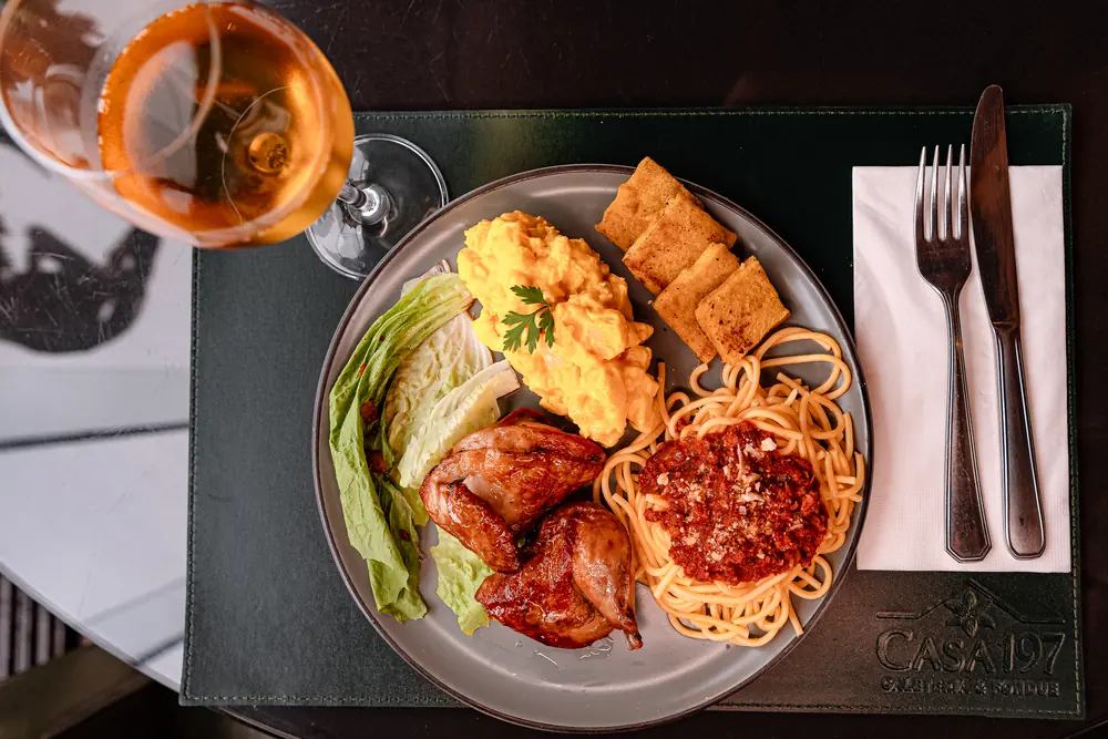 Prato de galeto com espaguete à bolonhesa, salada, maionese e polenta frita